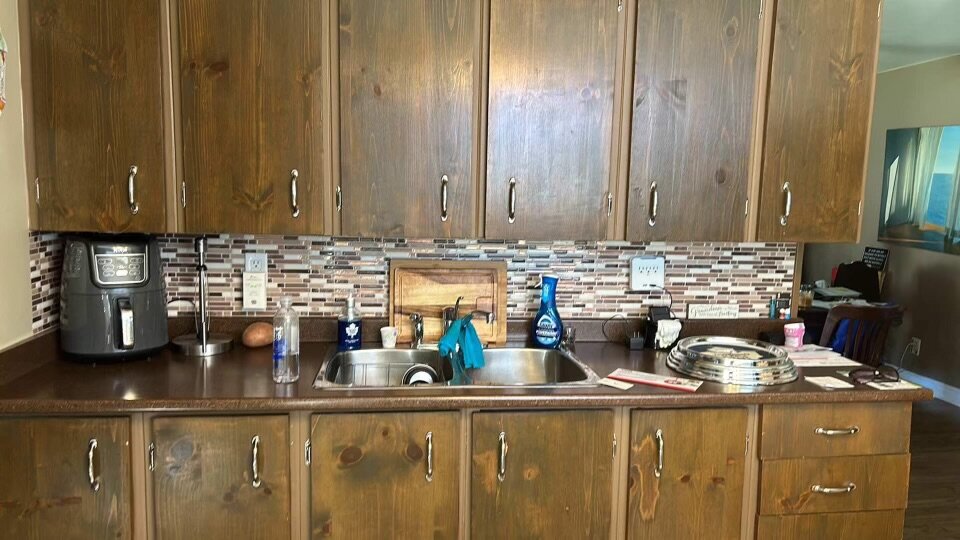 Kitchen before refinishing: dated dark wood cabinets